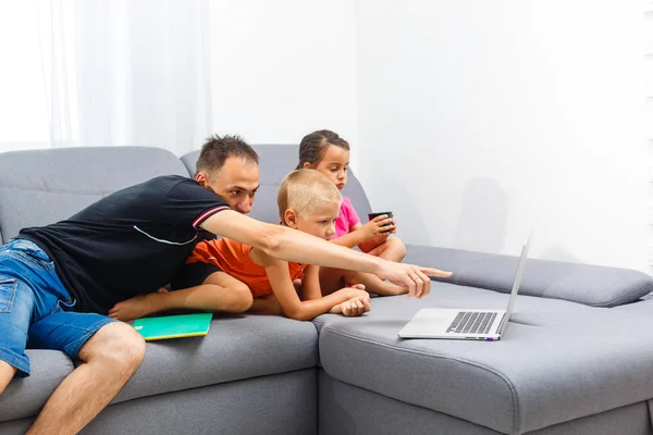 子供が父親の居間でノート パソコンを使用して — ストック写真