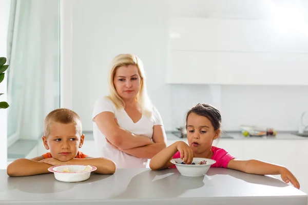 Jovem Mãe Alimentando Duas Crianças Cozinha Moderna — Fotografia de Stock