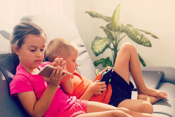 Due Bambini Che Usano Smartphone Tablet Siedono Sul Divano — Foto Stock
