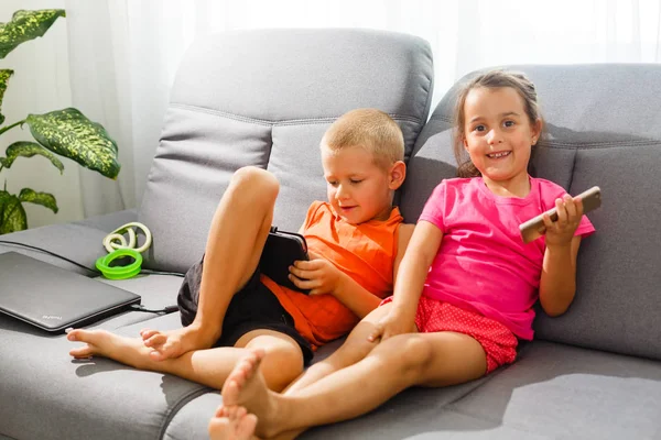 Dos Niños Usando Smartphone Tableta Sentados Sofá —  Fotos de Stock