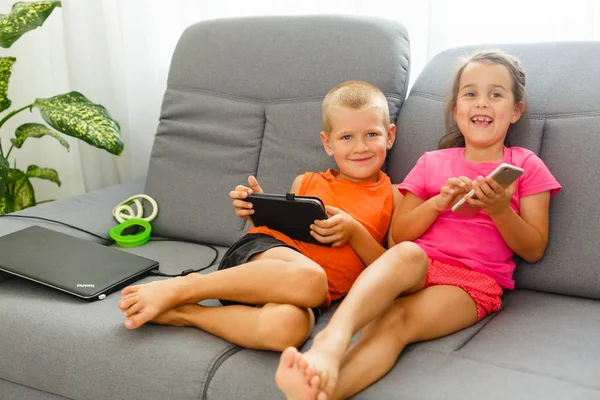 Due Bambini Che Usano Smartphone Tablet Siedono Sul Divano — Foto Stock