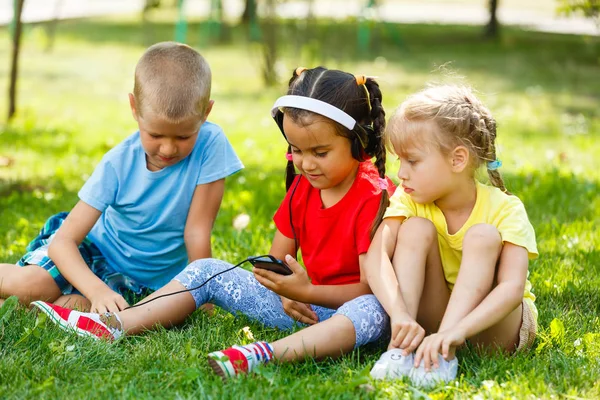 Compañía Niños Sentados Hierba Con Smartphone Parque —  Fotos de Stock