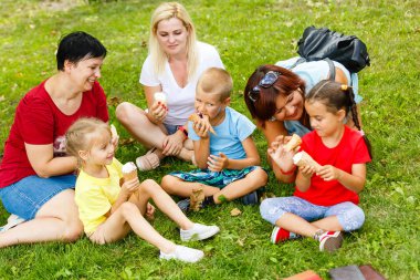 Aile içinde yeşil park dondurma yeme çocuklar ile