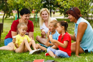 Aile içinde yeşil park dondurma yeme çocuklar ile