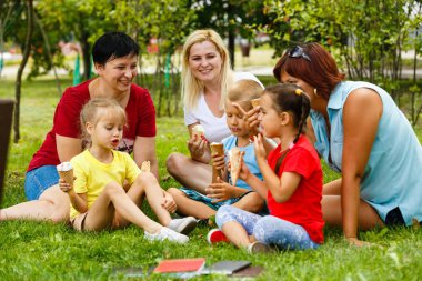 Aile içinde yeşil park dondurma yeme çocuklar ile