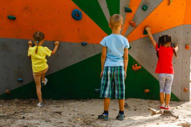 Çocuklar dışarıdaki duvara tırmanıyor.