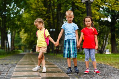 Yeşil parkta yürüyen neşeli çocukların portresi