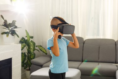 evde oturma odasında sanal gerçeklik gözlüğü kullanarak küçük çocuk