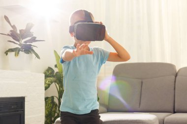 evde oturma odasında sanal gerçeklik gözlüğü kullanarak küçük çocuk