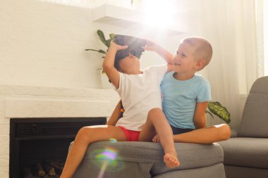 Oturma odasında sanal gerçeklik kulaklık kullanarak kardeş