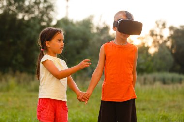 küçük kız kardeşiyle birlikte parkta oynarken sanal gerçeklik kulaklıklar