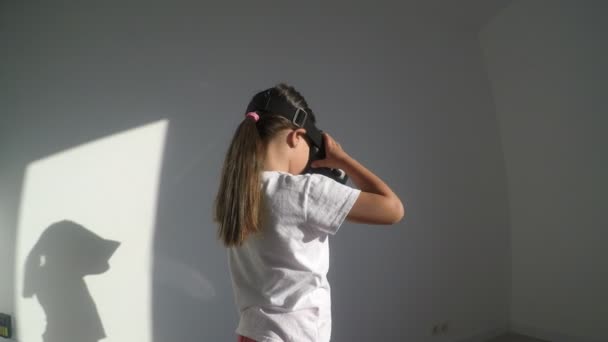 白の背景にバーチャルリアリティヘッドセットを持つ小さな女の子 — ストック動画