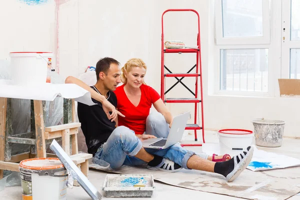 Casal Jovem Fazendo Reparação Apartamento Usando Laptop — Fotografia de Stock