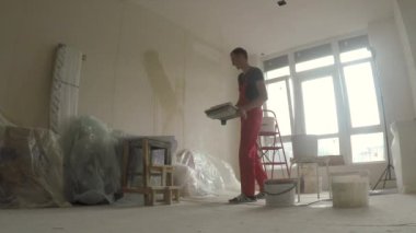 Yeni dairende onarım yapan genç erkek çalışır 