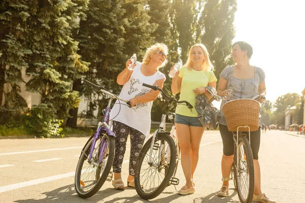3人の大人の女性が水を飲み 自転車に乗った後に休む — ストック写真