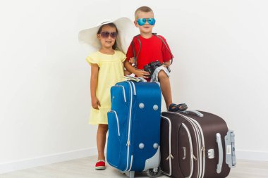 Kız ve erkek kardeşim ile beyaz arka plan üzerinde poz Bagaj seyahat 