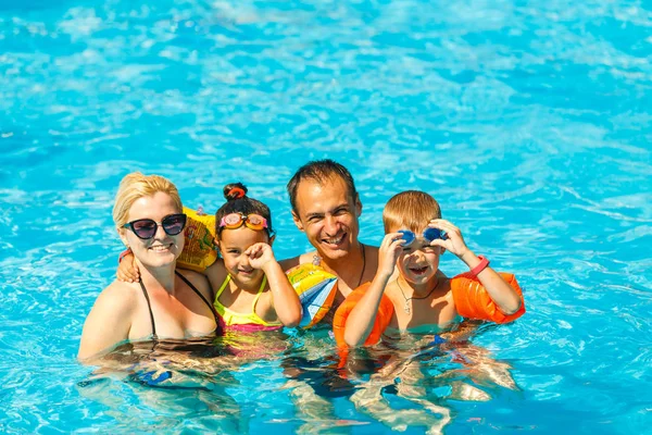快乐的家庭与两个孩子在游泳池的乐趣 — 图库照片