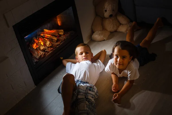 Liten Flicka Och Pojke Sitter Med Fall Framför Öppna Spisen — Stockfoto