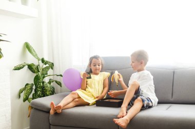 Hafif oturma odasında kanepede oynayan erkek ve kız 