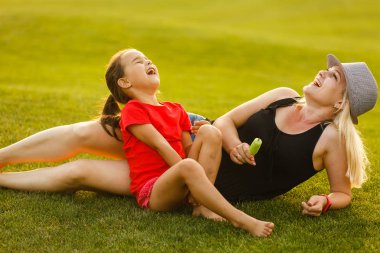 Genç anne kızıyla bahar parkında vakit geçiriyor.