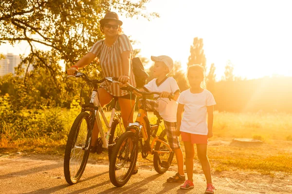 Mujer Feliz Con Hijo Hija Montando Bicicletas Atardecer — Foto de Stock
