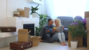 Genç bir çift söz ve kahve fincanı evde şömine yakın katta otururken sarılma