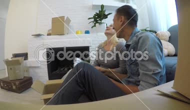 Genç çift gülüyor ve aile albümü evde şömine yakın katta otururken dikkate alınarak