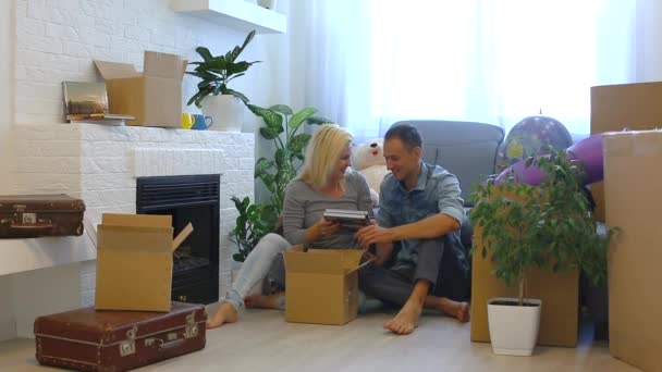 Young Couple Putting Family Albums Cardboard Box While Sitting Floor — Stock Video