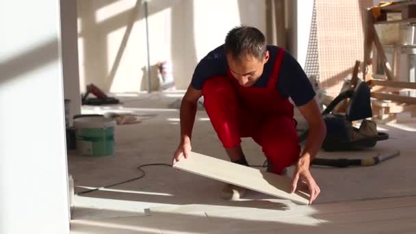 Jeune homme installant des carreaux de céramique 