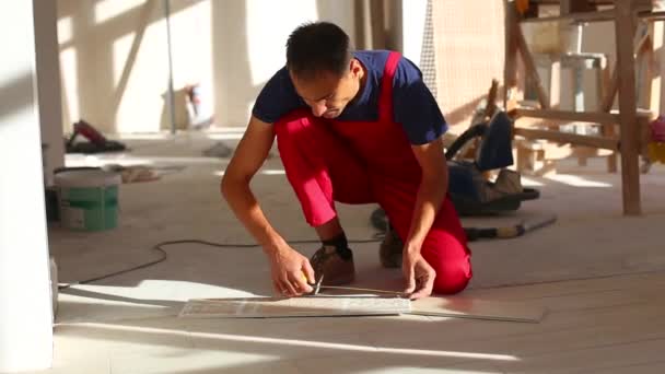 Молодий Чоловік Встановлює Керамічну Плитку Підлоги — стокове відео