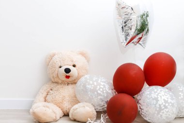 Beyaz arka plan üzerinde izole renkli balonlar ile Teddy ayı 
