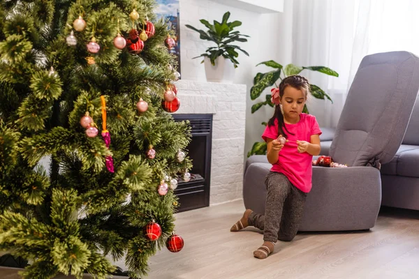 Niedliches Kleines Mädchen Mit Weihnachtsschmuck Spielen Während Auf Dem Boden — Stockfoto