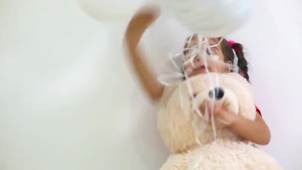 Hübsches Mädchen Hält Bärenspielzeug Und Spielt Mit Luftballons Auf Weißem — Stockvideo
