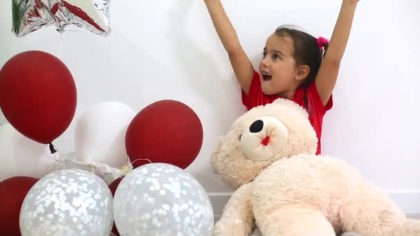 Little Beautiful Girl Raising Hands While Sitting Bear Toy Colorful — Stock Video