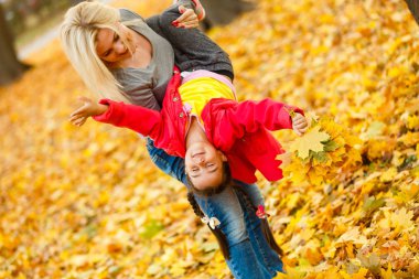 Anne ve kızı sonbahar sarı parkta eğleniyor