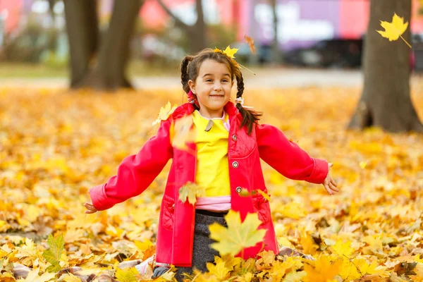 Гарна Маленька Дівчинка Червоній Куртці Грає Осіннім Апельсиновим Листям Парку — стокове фото