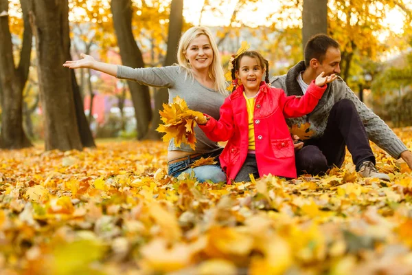 秋のオレンジで休んでいる間一緒に時間を過ごす幸せな家族葉屋外 — ストック写真