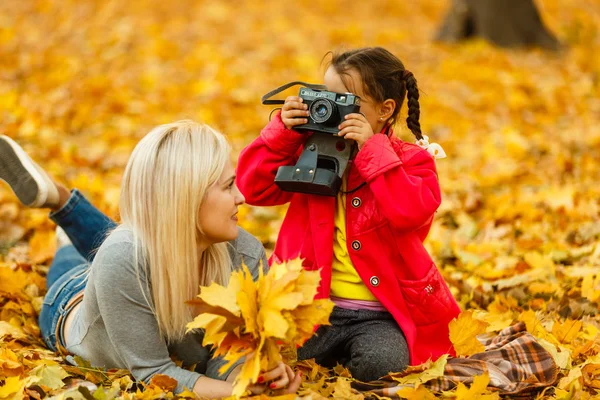 Madre Figlia Divertono Con Fotocamera Retrò Mentre Riposano Foglie Arancia — Foto Stock