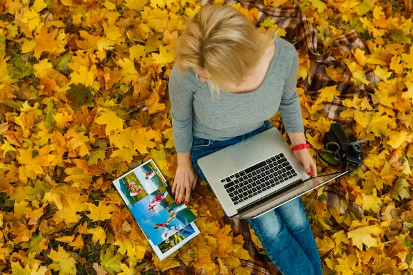 Kvinna Med Laptop Och Familjealbum Sittande Orange Höstlöv Park — Stockfoto