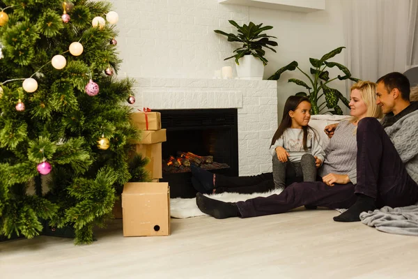 Familie Sitzt Auf Dem Fußboden Neben Kamin Und Weihnachtsbaum Wohnzimmer — Stockfoto