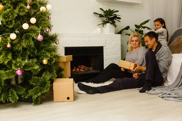 Familie Mit Geschenk Sitzt Auf Dem Fußboden Neben Weihnachtsbaum Wohnzimmer — Stockfoto