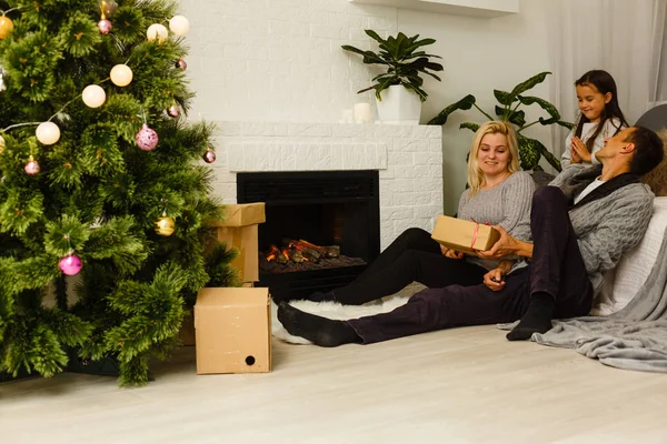 Familie Mit Geschenk Sitzt Auf Dem Fußboden Neben Weihnachtsbaum Wohnzimmer — Stockfoto