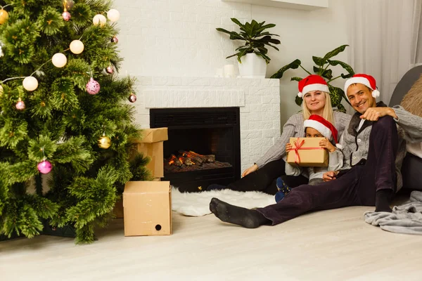 Famiglia Rosso Cappelli Babbo Natale Con Presente Seduto Piano Vicino — Foto Stock