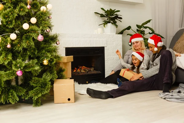 Família Chapéus Papai Noel Vermelho Com Presente Sentado Chão Perto — Fotografia de Stock