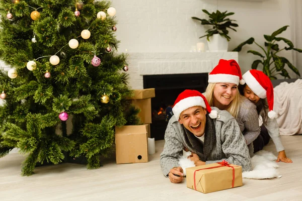 Famiglia Rosso Cappelli Babbo Natale Con Presente Sdraiato Sul Pavimento — Foto Stock