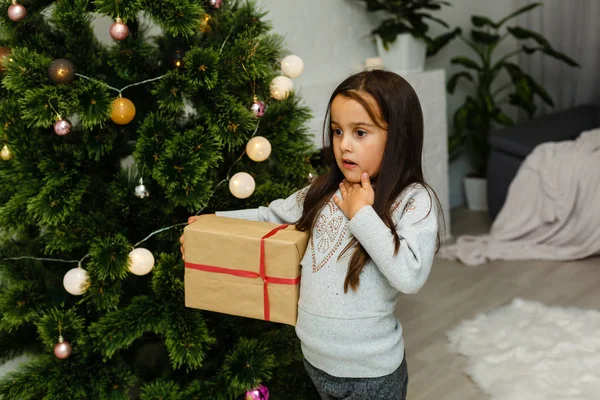 ギフト ボックス クリスマス ツリーの横に立っている幸せな女の子 — ストック写真