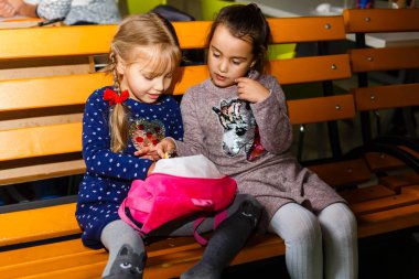 Bankta oturan ve öğle yemeği iki kız kardeş