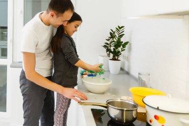 Baba ve kızı mutfakta birlikte yemek yapıyorlar. Aşçılık dersleri konsepti