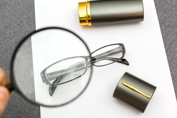 玻璃杯和放大镜放在一张纸片上 用于在盲眼后做生意 — 图库照片