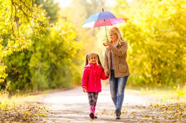 Anne ve kızı bahar sokağında şemsiyeli.
